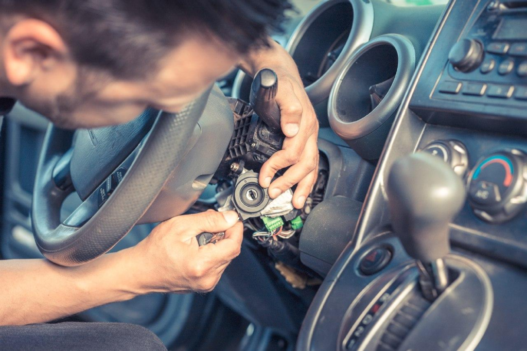 A person replacing the ignition switch of a car